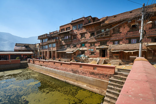 Red brick newar house and the green pond in Kirtipur, Nepal