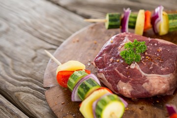 Sirloin chop with skewered vegetables on wooden tray
