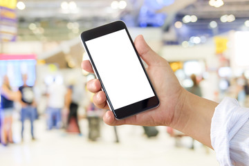 Man using smartphone in airport terminal.