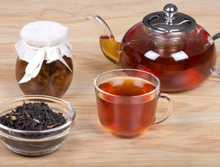 Чашка чая, чайник и банка с мёдом.