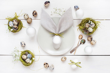 Easter table decoration with napkin in the form of rabbit ears, eggs and nests