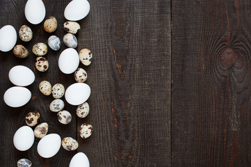 Wooden background with various chicken and quail eggs