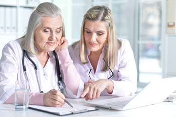 doctor and her colleague using laptop