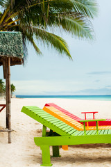 Obraz na płótnie Canvas transats colorés sur une belle plage sous un cocotier