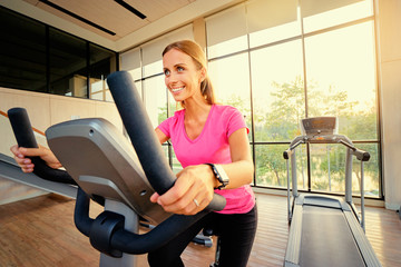 Healthy lifestyle and sport. Pretty young woman exercising in gym.