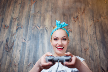 Young blond woman playing with console joystick.