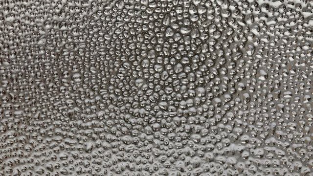 Water drops at glass, or transparent surface vertical panning footage