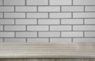 Blurred and abstract background. Empty wooden tabletop and defocused brick wall background for display or montage your products.