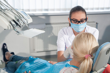 Female dentist examining a patient in the dental office for a woman