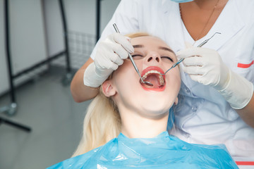 The dentist examines the patient using mirror