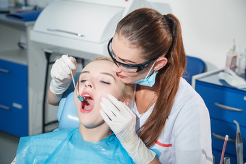 The dentist examines a patient in the dental office