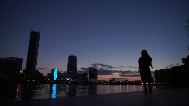 Silhouette of the girl at night on the river bank