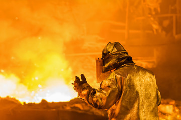 Worker metallurgist working in the domain shop, industrial background