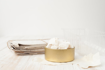 a bunch of old letters, torn paper, plastic container, iron pot on white wooden background