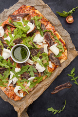 Pizza on dark wooden background top view