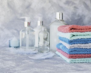 stack of towels for bathroom bottles on a white marble background, space for text, selective focus