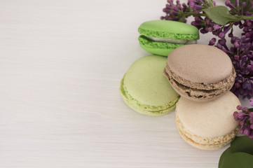 French macarons with twigs of lilacs. Close-up. Background with flowers and macaroons.