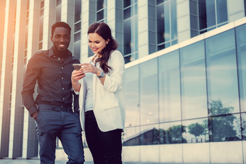 Black male and brunette Caucasian woman in a downtown.