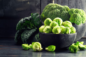 Ingredients Brussels Sprout with Broccoli, kale on black wooden table. Selective focus