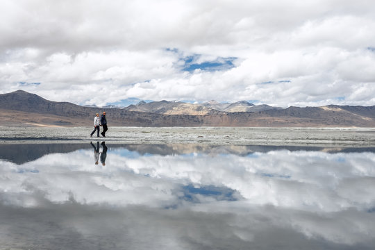 Two travelers walks near Tso Kar Lake in Himalaya Mountain