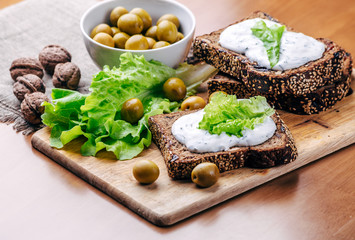 Sandwiches of homemade bread with cheese sauce or cream, lettuce, walnuts, olive