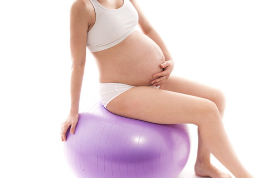 Pregnant woman doing gymnastics on a fitball