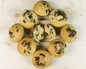 Square of muffins with chocolate drops on wood - top view