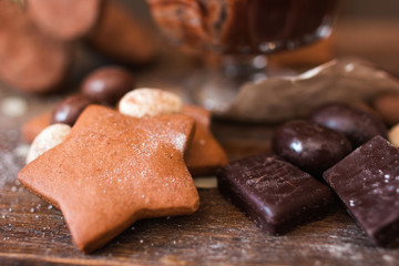 Cookie star with chocolate on wood closeup. Sweets variety on wooden table, confectionery background. Sweet tooth, dessert, pastry, kids paradise concept