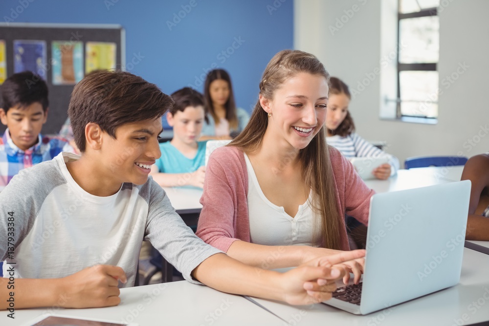 Wall mural Students using digital tablet and laptop in classroom