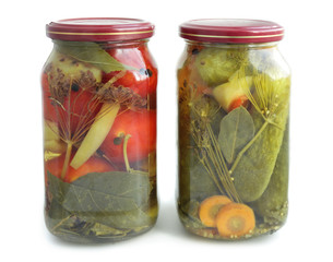 Jars wih pickled cucumbers and tomatoes isolated on white