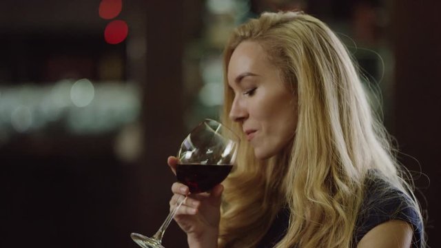blurred view of lady drinking red wine