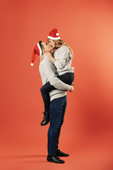 Cheerful couple in winter clothes hugging and kissing
