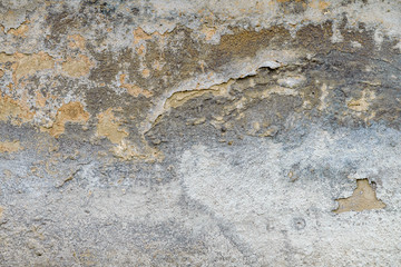 old house wall with cracked plaster. grunge textured background