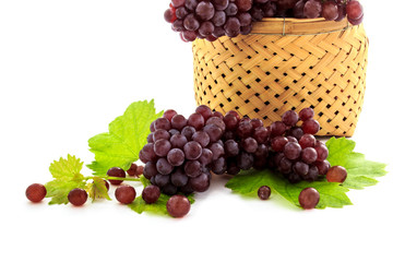 Ripe fresh Organic Table grapes, Champagne Grapes with grape leaves in wicker basket isolated on white background. Small fruit, Snacks for Weight Loss and Diet. Selective focus.