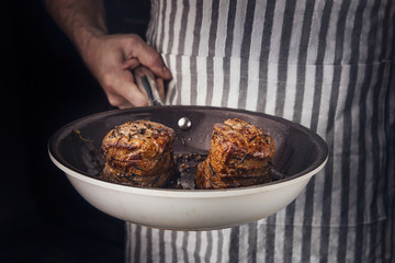 Man holding fraying pan with two steaks prepaid