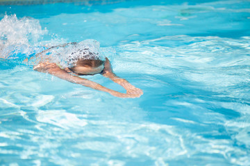 Pretty female swimmer in a pool, getting her daily dose of exercise without stressing her joints