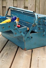 an old metal toolbox on a wooden garden table