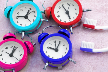 Macro view of composition from toothbrushes and colorful clocks