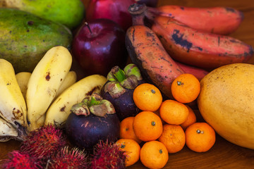 Tropical fruits on wooden table, top view