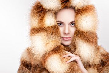 portrait of beautiful young blonde woman in luxury Fox fur coat.