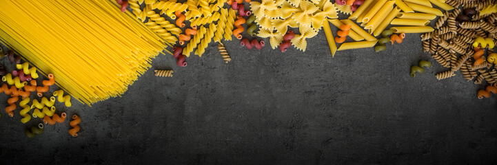 Various types of pasta - spaghetti, penne, fusilli, colored vegetables pasta.