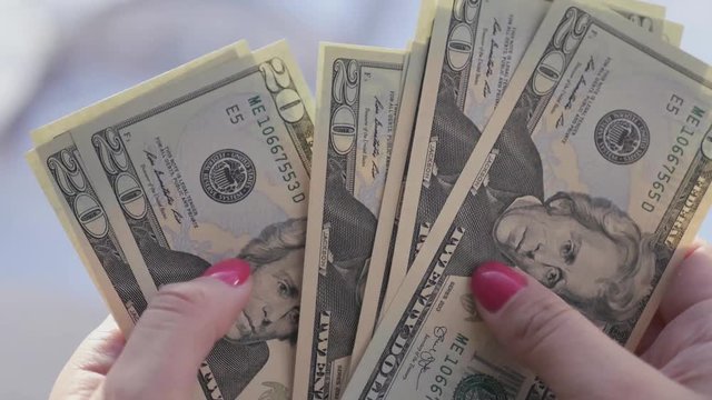 beautiful girl with pink nails, holds a 20 dollar denominations in his hands and count them, 4k., 3840x2160