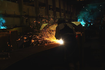 Welder arc Gouging carbon electrode rods   with sparks and smoke in  factory