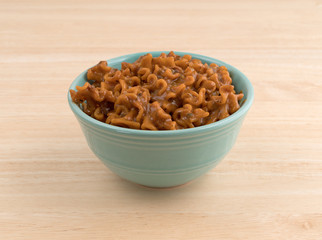 Marinara pasta in a bowl on a wood table top.