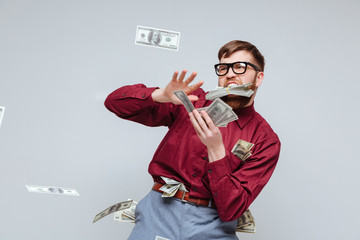 Happy Male nerd playing with money