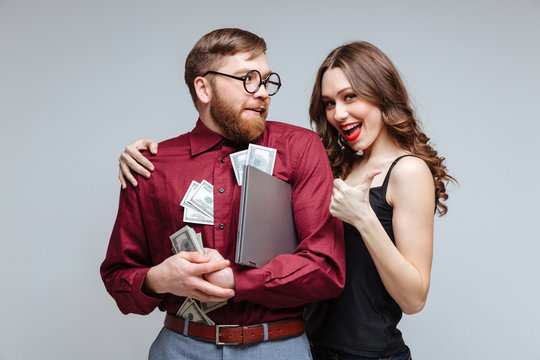 Happy Woman Stick To Male Nerd With Money