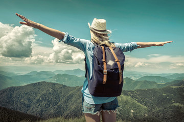 Woman hiking in mountains at sunny day time.