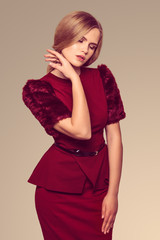 Fototapeta premium beautiful blonde woman posing in burgundy dress