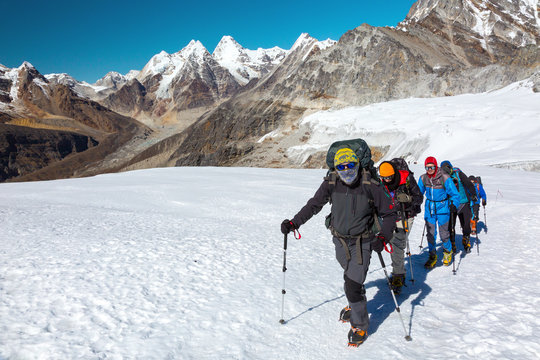 Severe Mountain Climbers in weather protective Clothing on Glacier