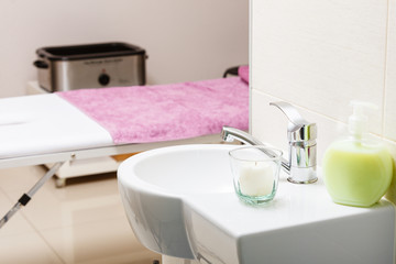 Fototapeta na wymiar Focused sink with candle in beautician spa salon